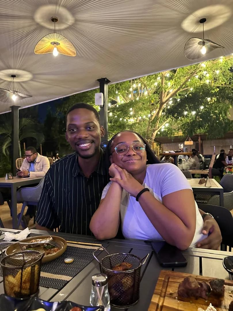 Divine et Matthieu souriants, assis à une table en terrasse