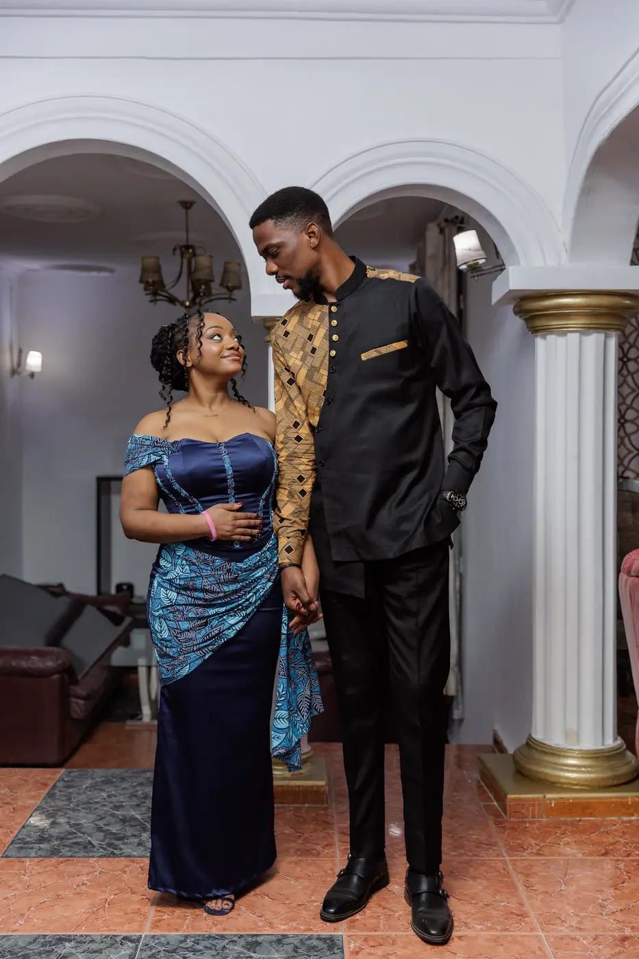 Divine et Matthieu en tenue traditionnelle bleue et noire, échangeant un regard