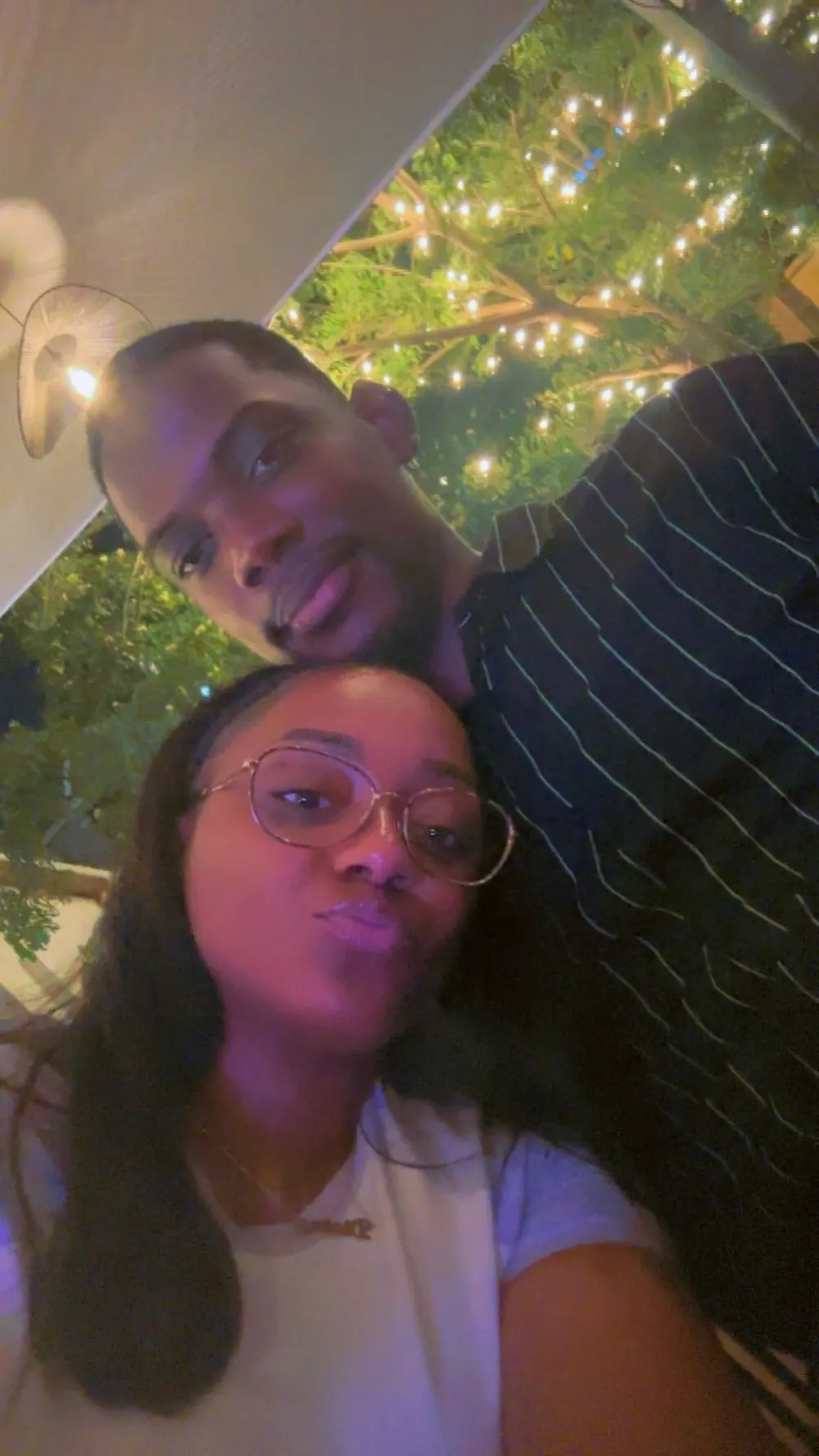 Selfie de Divine et Matthieu sous des guirlandes lumineuses